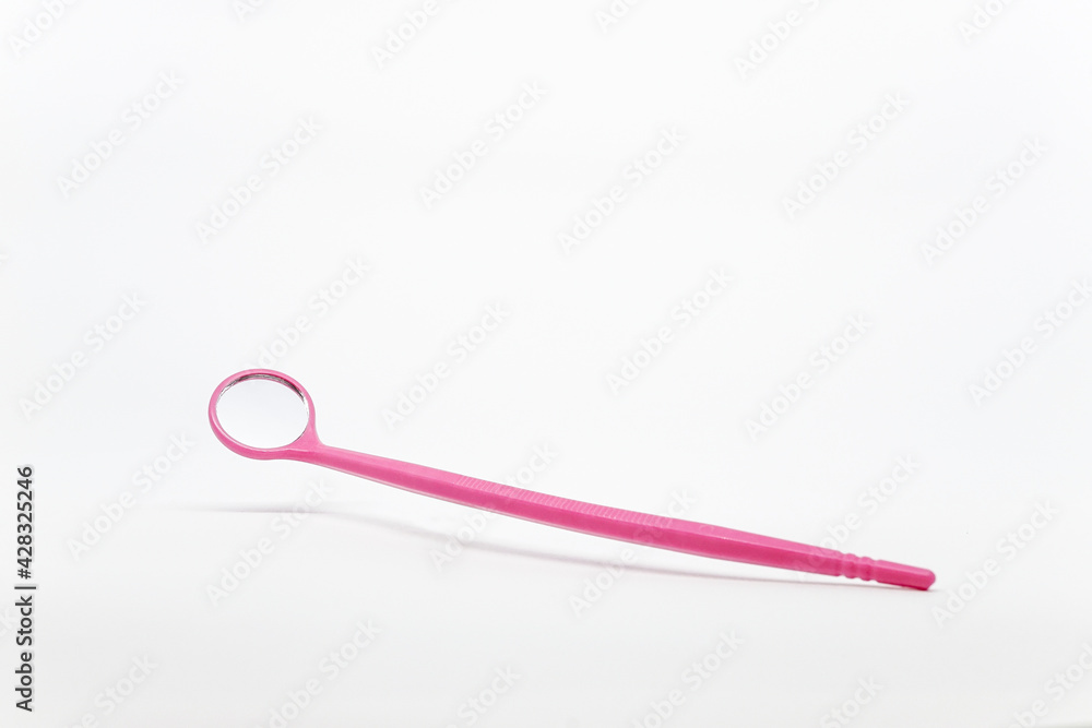 Mini pink eyelash extension mirror made of plastic on top of a white background. Mini pink eyelash extension mirror made of plastic on top of a white background.