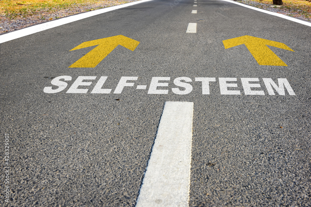 Self-esteem and yellow arrow sign marking on road surface for giving directions. Boosting self esteem concept and improvement idea