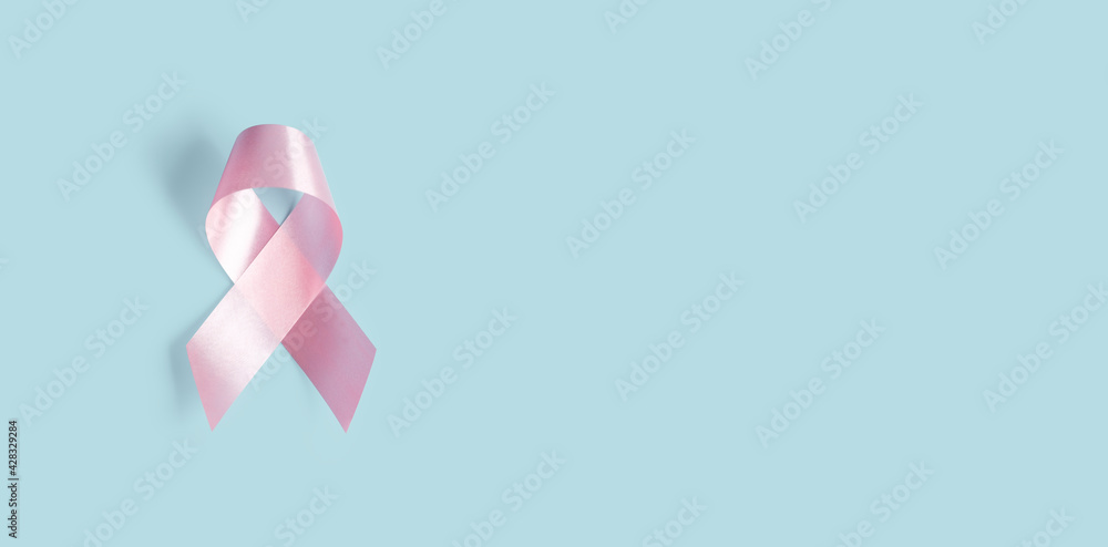 Pink ribbon on soft pastel blue background, breast cancer awareness, October pink, World cancer day concept	