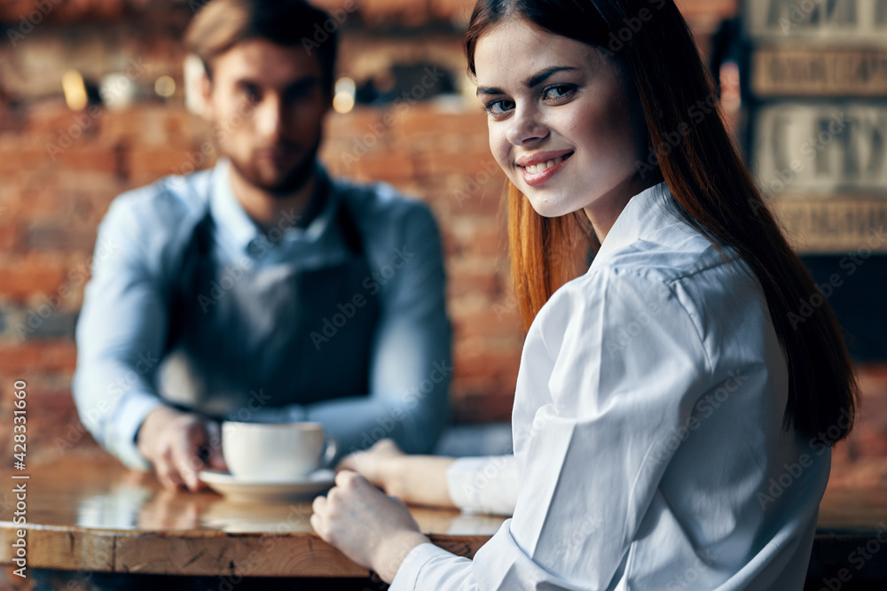 happy woman with cup of coffee and man bartender in apron