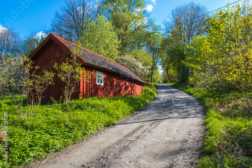 Idyllic red barn at dirt road at springtime © Lars Johansson