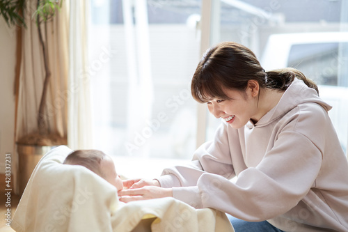 赤ちゃんと遊ぶアジア人のお母さん