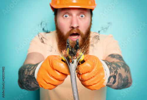 Incompetent worker electrician is unsure about his work. cyan background