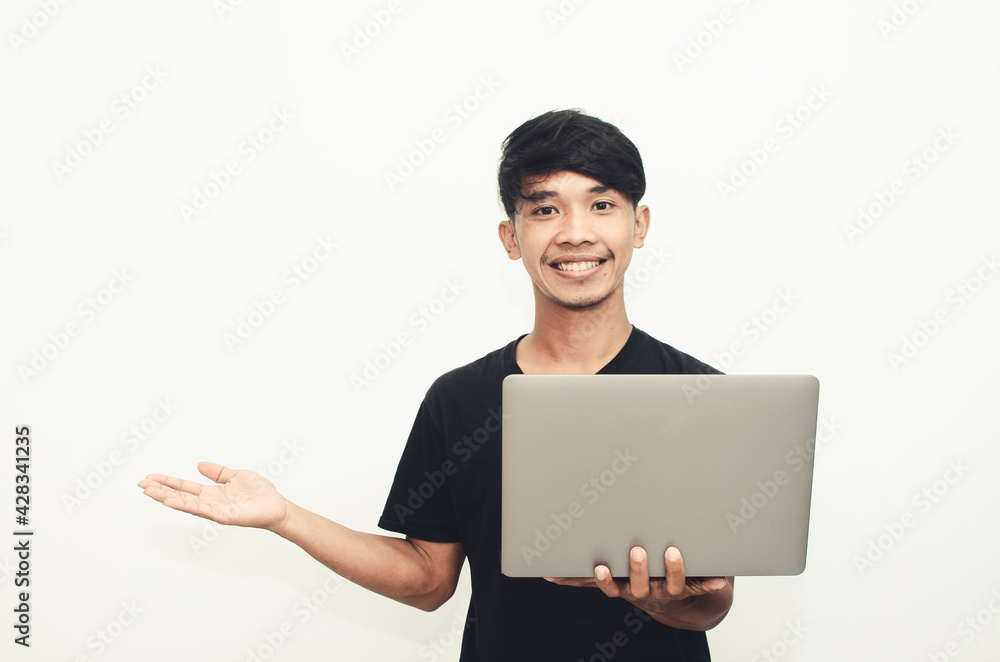 An Asian man wearing a casual black T-shirt carries a laptop with the expression of finding ideas