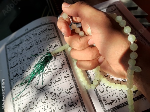 worship in ramadan / ramzan with tasbih and quran is how muslim pray in islam for allah photo