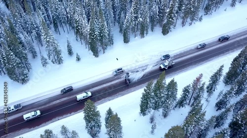 Pickup truck crashed and overturned in the middle of the road creating congestion traffic on icy road in the mountains in winter.