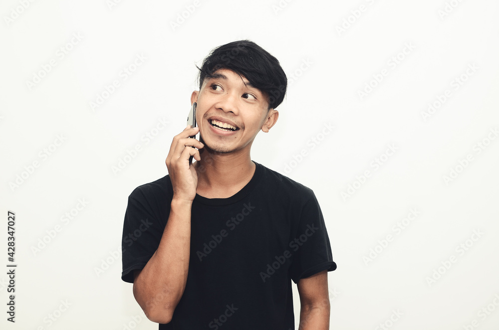 An Asian man wearing a casual black shirt is on the phone An Asian man wearing a casual black shirt is on the phone