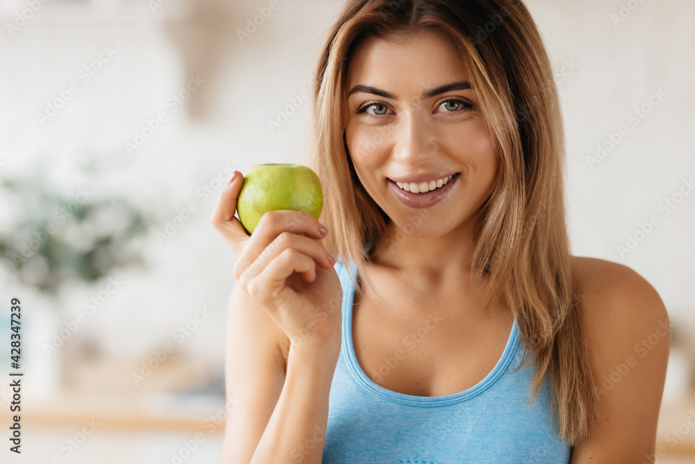 Beautiful lady posing with a green apple and smiling Beautiful lady posing with a green apple and smiling
