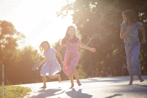 Childhood is best time of life. Three little girls running in the park.