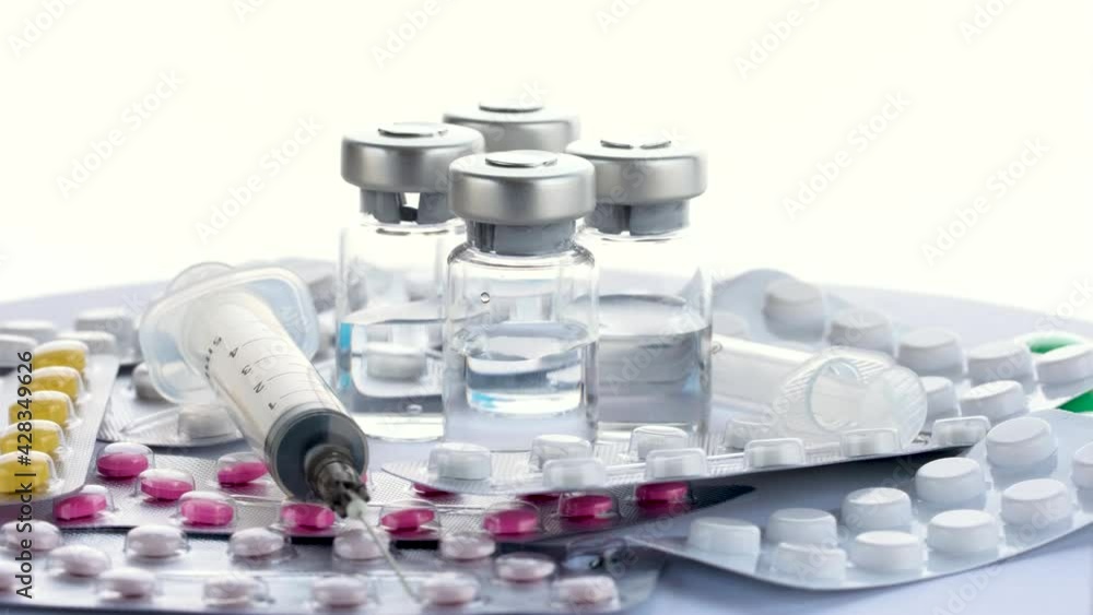 Various medicines, syringes and vials of vaccine from the virus covid 19 on white background rotation 360 degrees. Treatment for Coronavirus covid-19. Concept of Corona Virus Treatment, Injection, 4k Various medicines, syringes and vials of vaccine from the virus covid 19 on white background rotation 360 degrees. Treatment for Coronavirus covid-19. Concept of Corona Virus Treatment, Injection, 4k