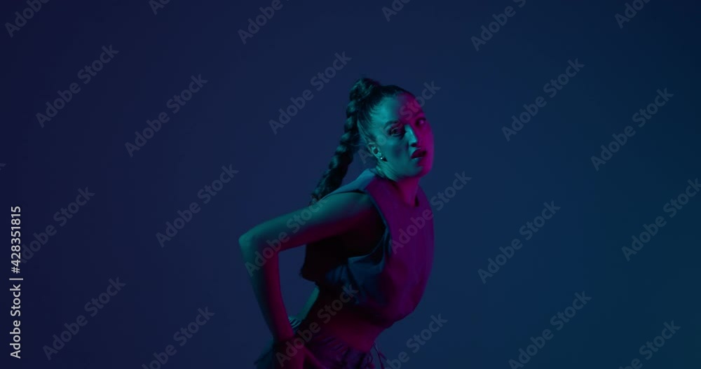 Young mixed race girl dancing fiery dance or hip-hop in neon studio light. Professional female performer Young mixed race girl dancing fiery dance or hip-hop in neon studio light. Professional female performer