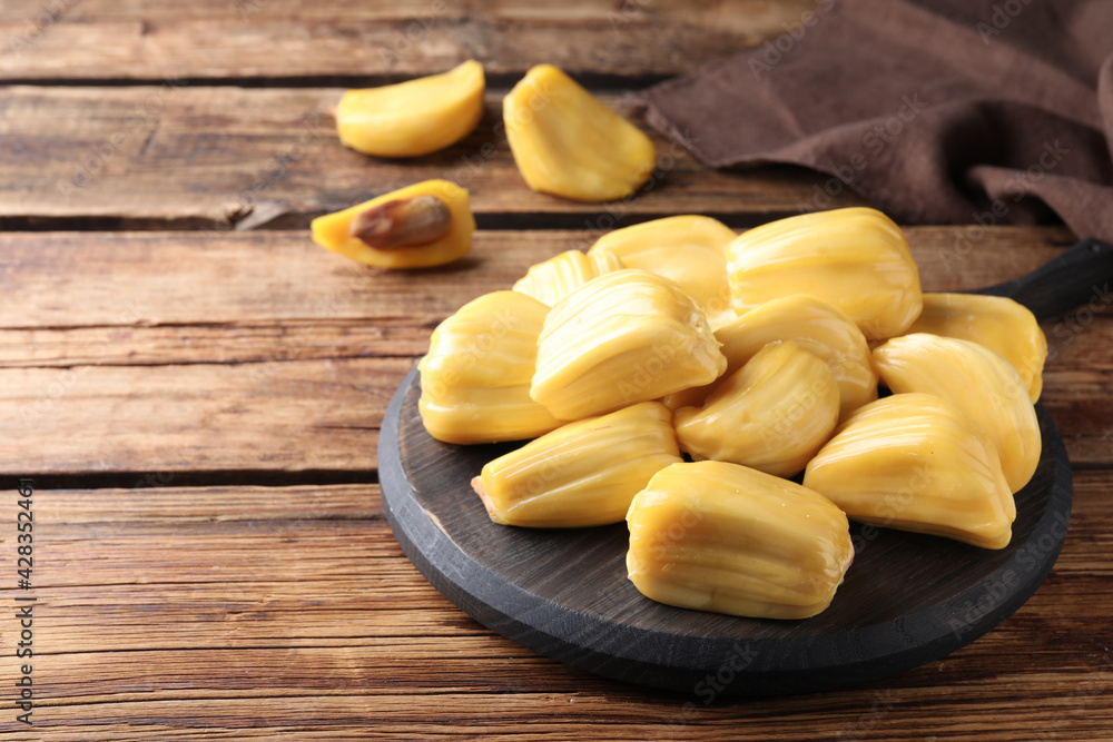 Delicious exotic jackfruit bulbs on wooden table