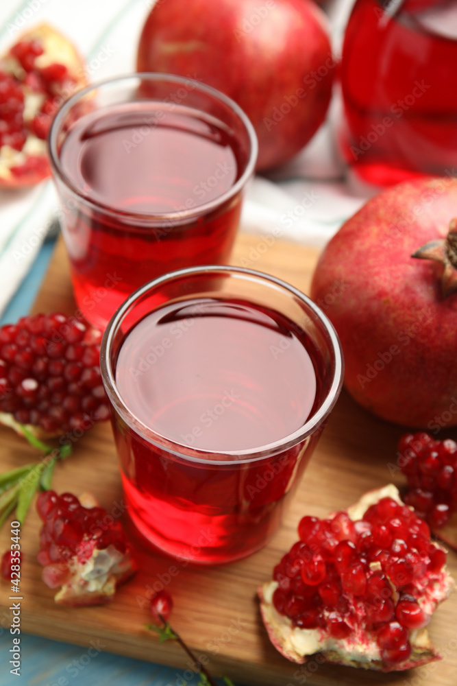 Pomegranate juice and fresh fruits on light blue wooden table Pomegranate juice and fresh fruits on light blue wooden table