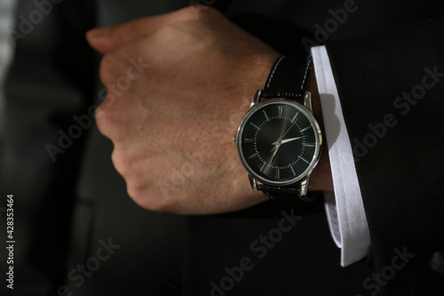 Businessman in suit with luxury wrist watch, closeup