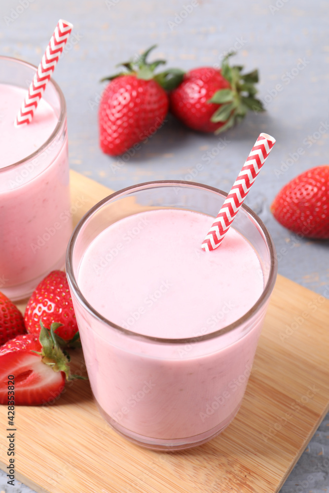 Delicious strawberry drink on light grey wooden table Delicious strawberry drink on light grey wooden table