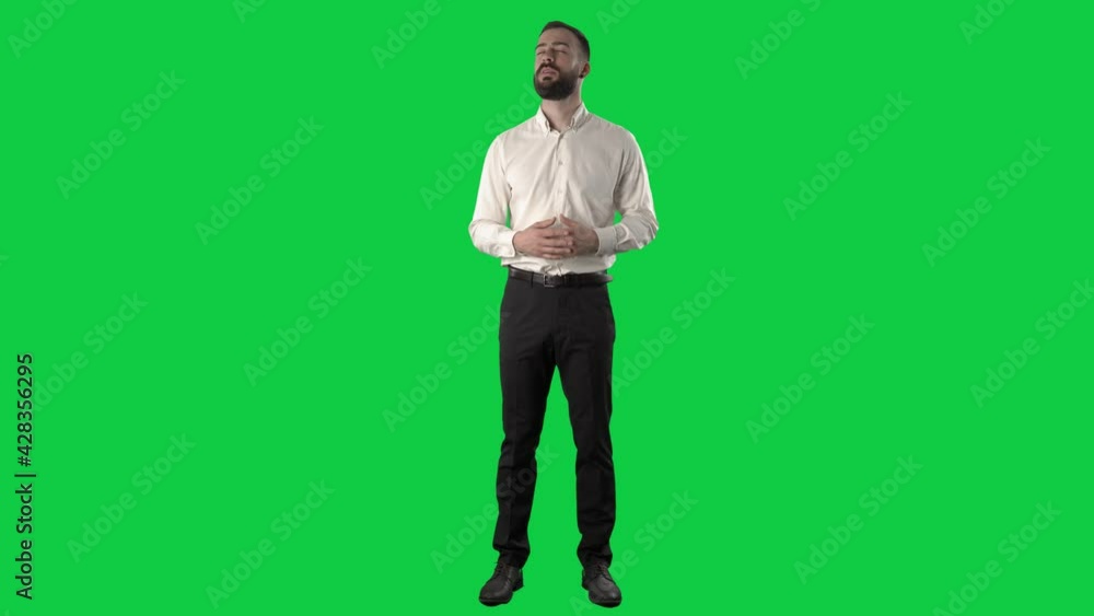 Confident happy business man announcing and talking looking at camera with gesticulation. Full length on green screen chroma key background.