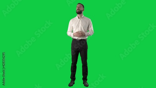 Confident happy business man announcing and talking looking at camera with gesticulation. Full length on green screen chroma key background.