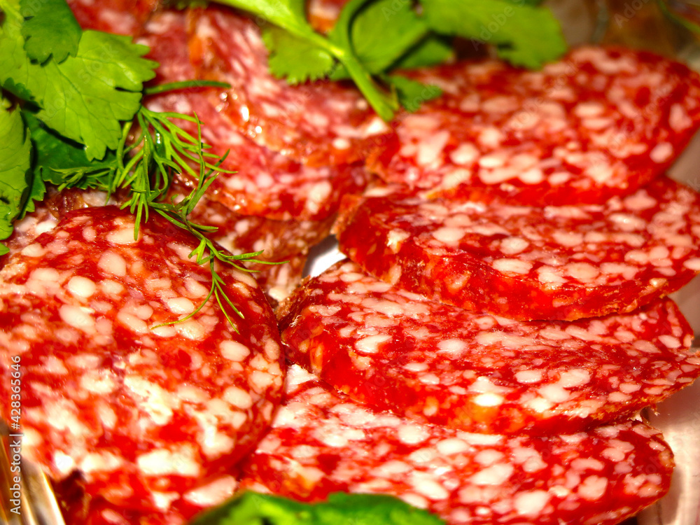 salami sausage with herbs on the festive table is sliced salami sausage with herbs on the festive table is sliced