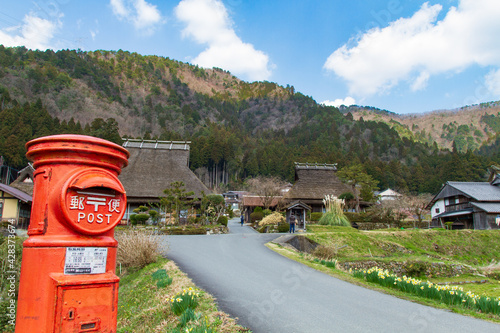 An old house with a red mailbox and thatched roof in Kitamura, Miyama Kayabuki no Sato, Nantan City, Kyoto Prefecture, Japan photo