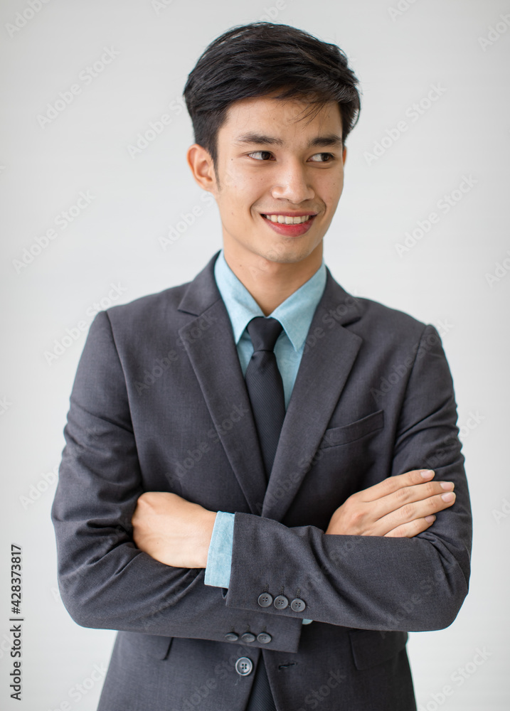Positive Asian entrepreneur against gray wall Positive Asian entrepreneur against gray wall