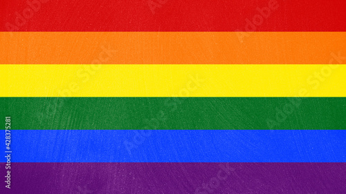 The rainbow flag (a symbol of lesbian, gay, bisexual, transgender, and queer pride) over a dirty blackboard texture. 