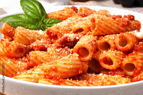 Fotografie Delizioso piatto di rigatoni conditi con sugo all'amatriciana e spolverato con formaggio grattugiato