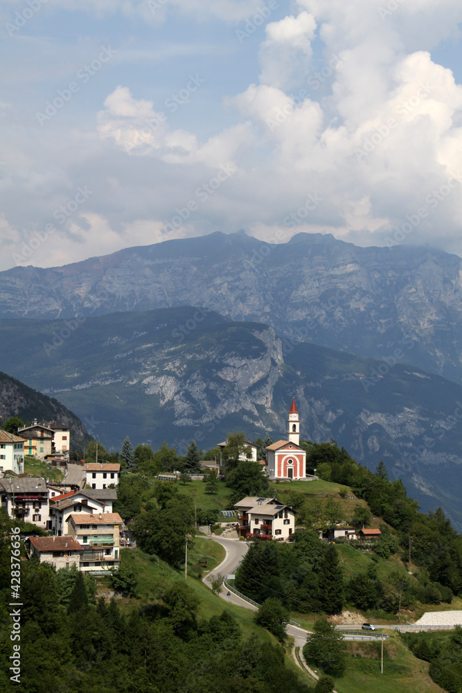 Mountain landscape with the town of Guardia and its small church, Trentino, Italy