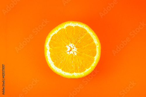 Close up photo of orange texture on the orange background. Fruit cut in half  inside  macro view. Minimalism  original and creative image. Beautiful natural wallpaper.