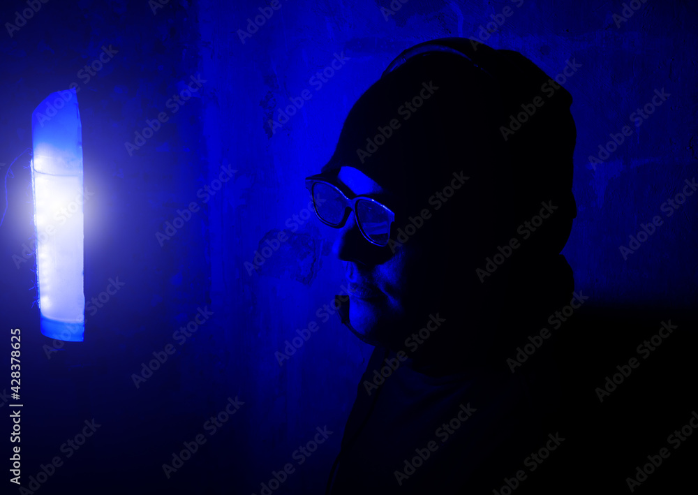 Sound recording studio. Young man in glasses and headphones on the night party in nightclub with neon lights. Have fun tonight. Holidays entertainment.