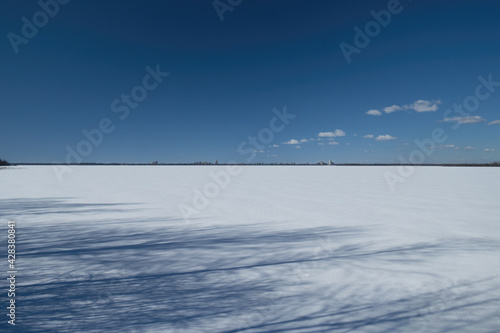 Frozen lake under snow on a clear winter day.