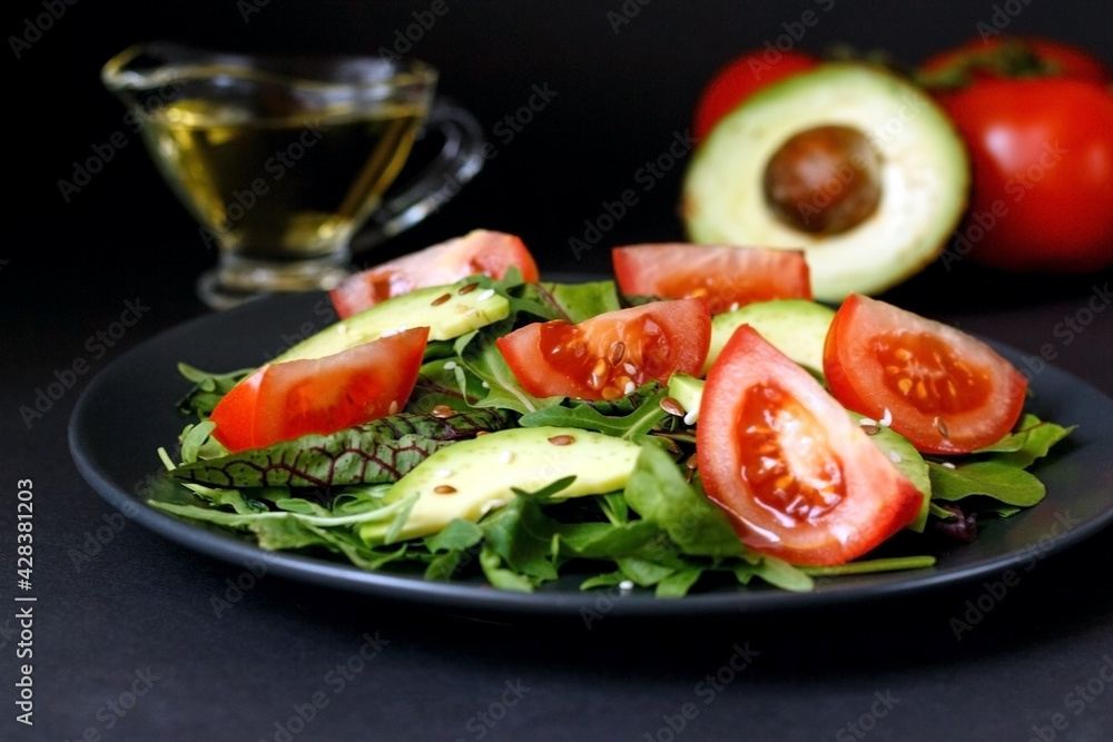 Green tossed salad with leafy vegetables, arugula, baby spinach, avocado, tomatoes and seeds. Ketogenic low-carb diet food Green tossed salad with leafy vegetables, arugula, baby spinach, avocado, tomatoes and seeds. Ketogenic low-carb diet food
