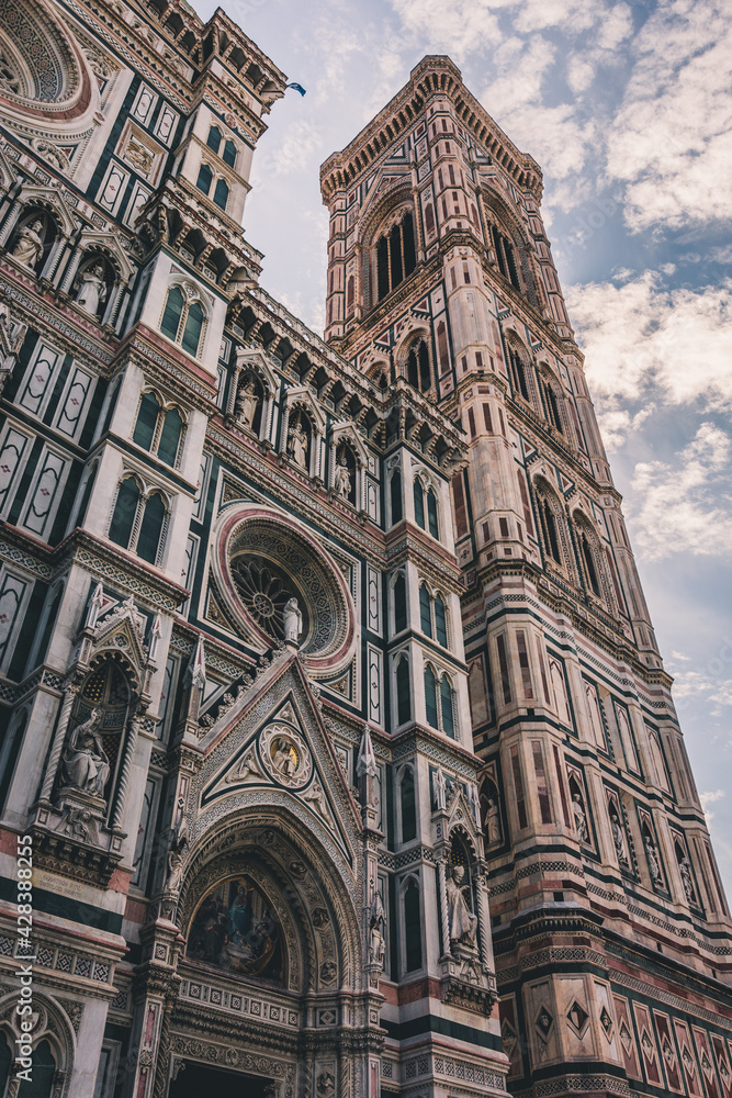 Close up. The white marble facade, exterior, of the central church, Duomo, also known as Santa Maria del Fiore Cathedral, with the tower and the Renaissance dome in Florence, Tuscany, Italy. Europe