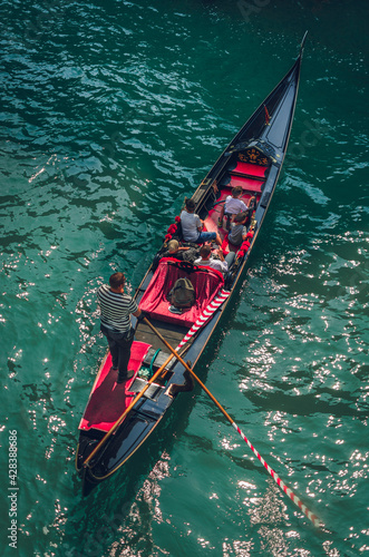 Venetian gondola, Scenic canal ride in colorful channel, top tourist summer activity in Venice, Italy