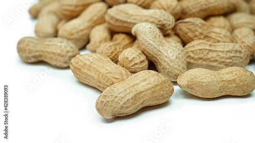 Heap of dried peanuts, Monkey nuts, Groundnuts, Isolated on white background, Close up