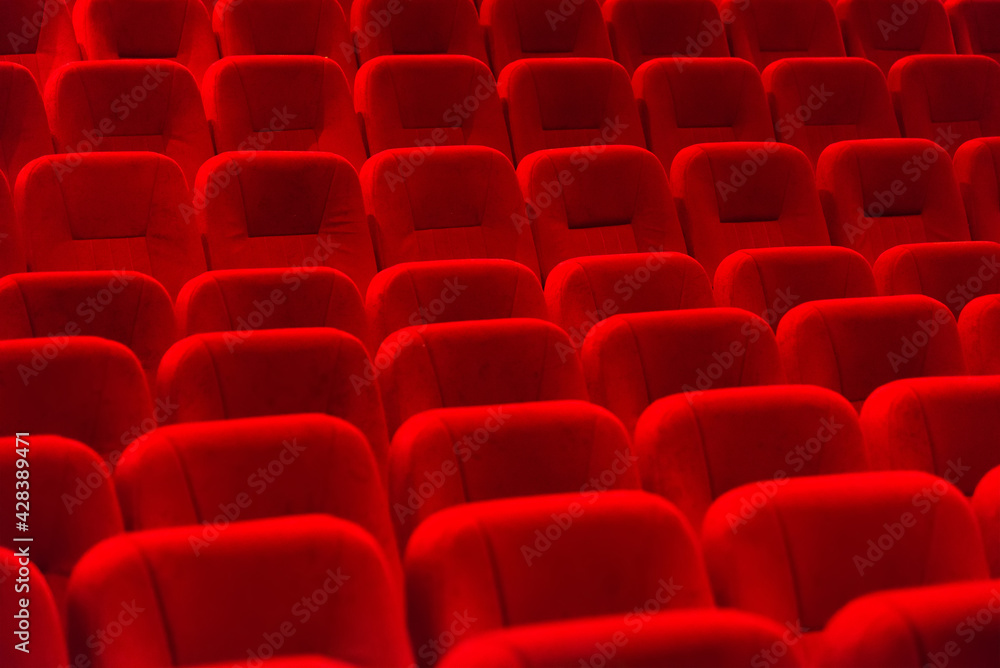 Naklejka premium empty red velvet seats in cinema auditorium