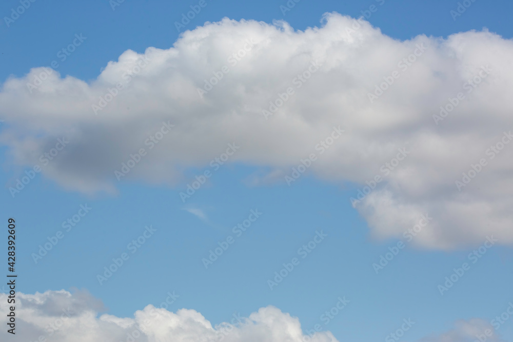 Obraz premium white fluffy clouds on a blue sky background