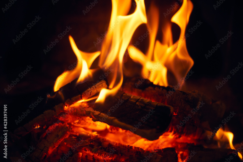 A fire burns in a fireplace, Fire to keep warm. Logs burning in a fireplace A fire burns in a fireplace, Fire to keep warm. Logs burning in a fireplace