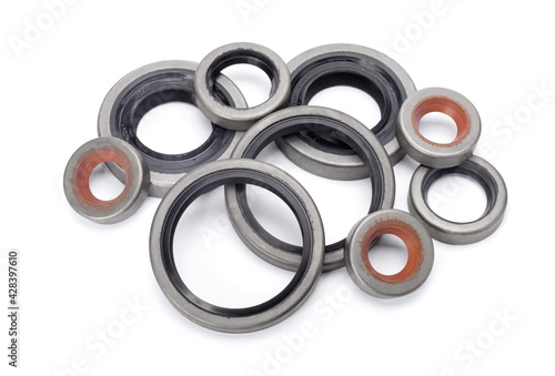 Pile of different rubber reinforced oil seals for shafts and for car motor engines isolated on white background. Cuffs for prevent liquid leak. Car parts.