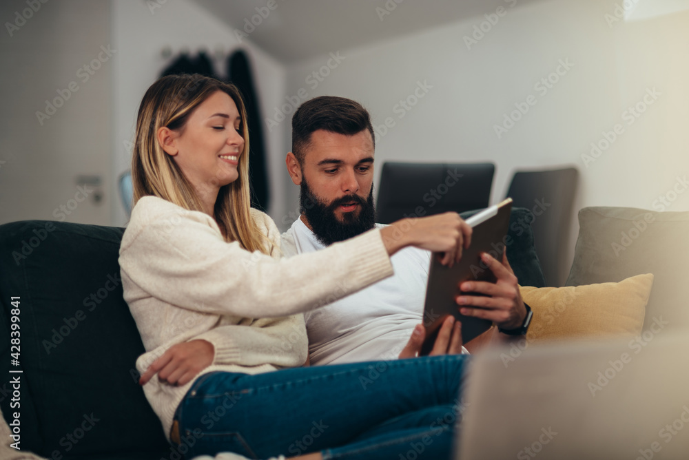 Couple using a tablet at home Couple using a tablet at home