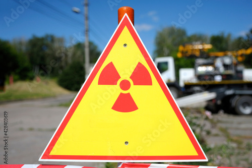 Radiation hazard sign, trees and truck on a background photo