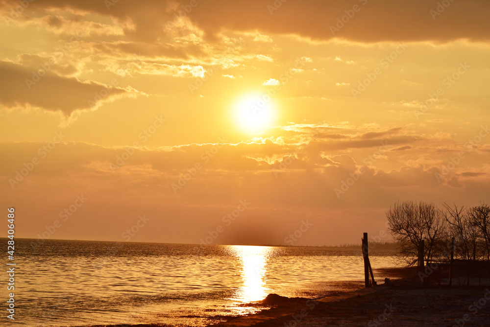 Sunset sky at the seaside, cloudy golden sky in spring, amazing colors of photo