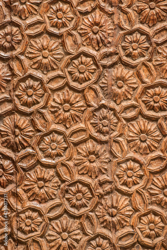 Woodcarving with floral motifs as detail of old wooden door closeup