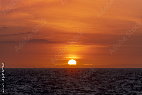 Warm and romantic sunset on the North Sea with small clouds hiding half of the sun © Ankor light