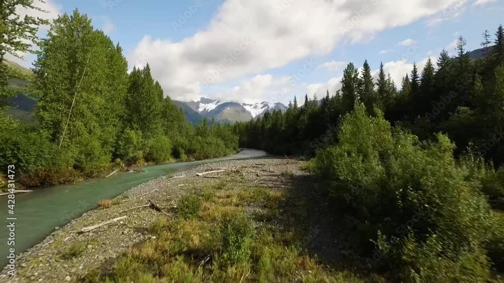 push in over a blue creek to a small bridge with mountains in the background push in over a blue creek to a small bridge with mountains in the background