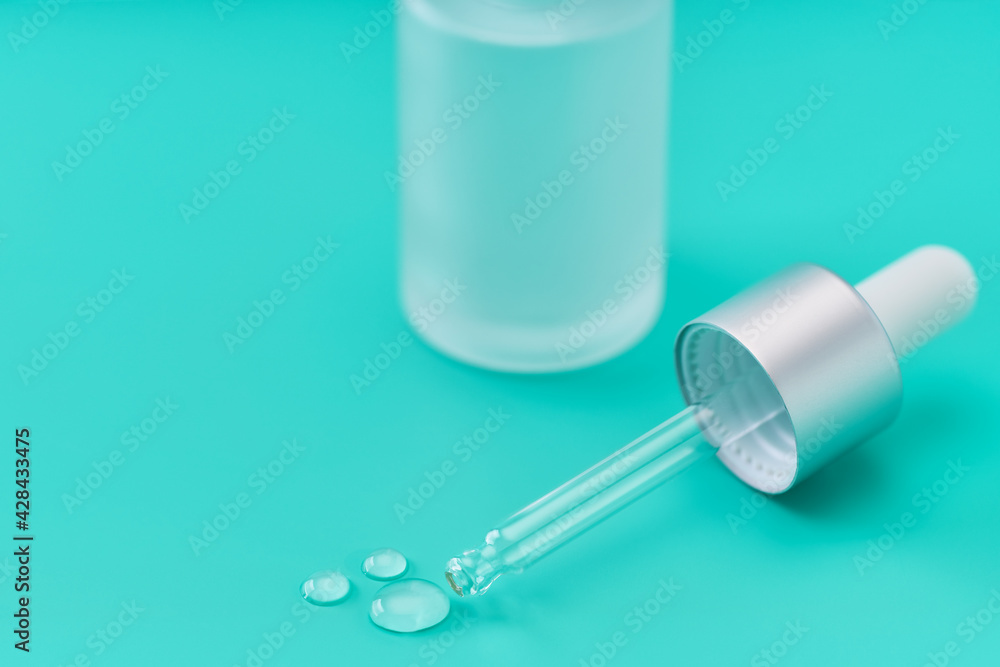 a drop of hydrating facial serum on a blue background. a drop of hydrating facial serum on a blue background.