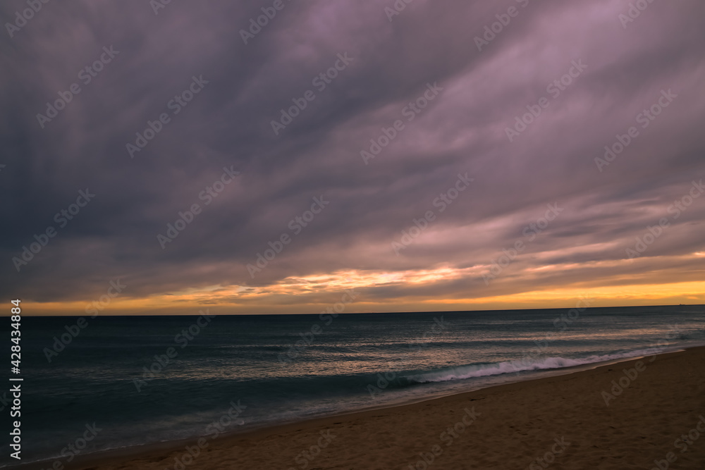 Sunset with windy clouds over the sea.