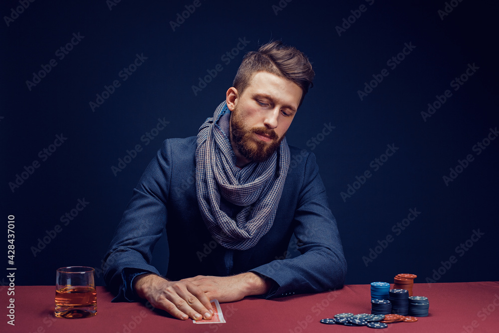 Stylish bearded Man in suit and scarf playing in dark casino, smoking cigar, drink whiskey Stylish bearded Man in suit and scarf playing in dark casino, smoking cigar, drink whiskey