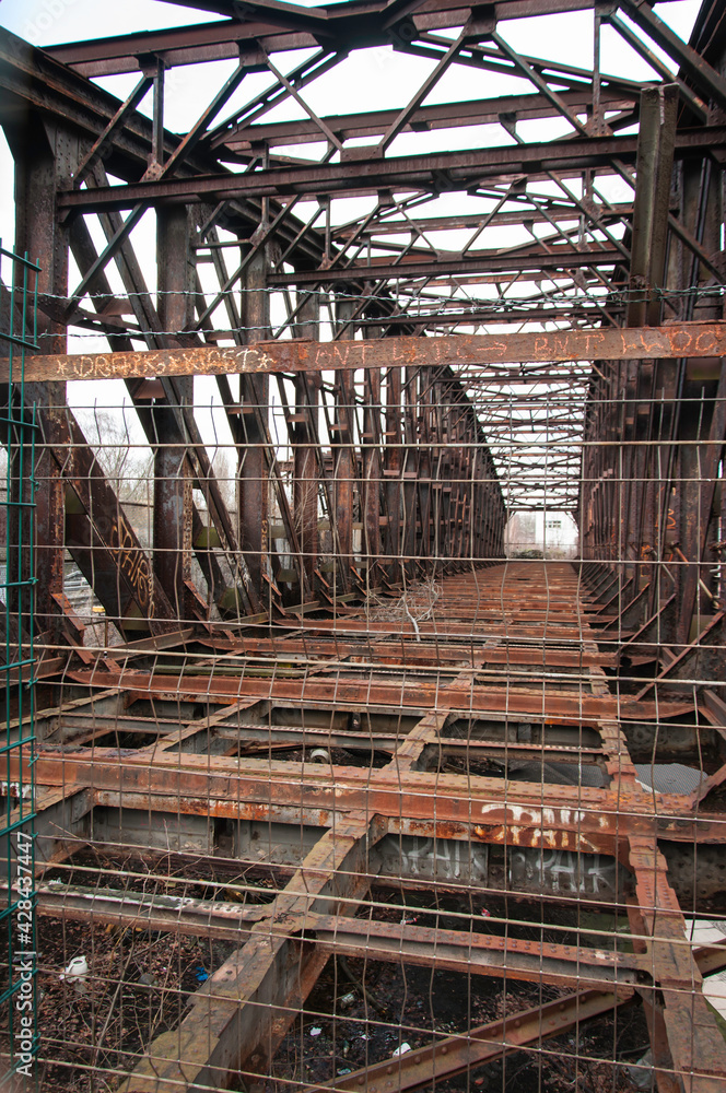 Detailansicht einer alten, nicht mehr genutzten Eisenbahnbrücke. Sie ist alt und sehr rostig.