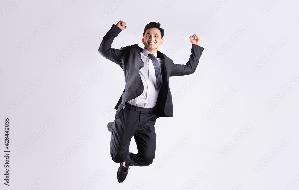 Young Asian businessman jumping on white background Young Asian businessman jumping on white background