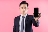 Image of young Asian businessman on pink background